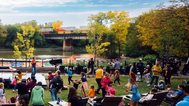 A women leading a crowd of children through a dance.